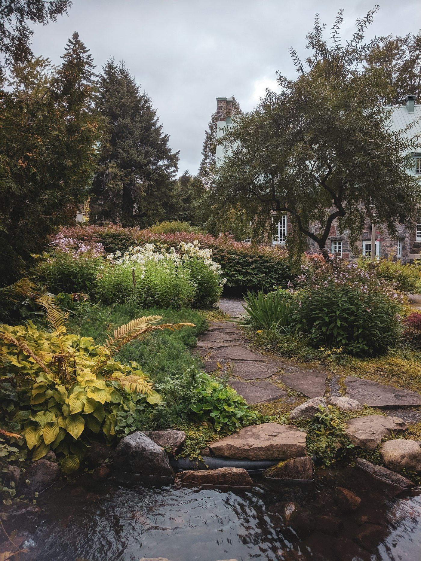 Üppig bepflanzter Staudengarten mit Natursteinweg in Braunschweig