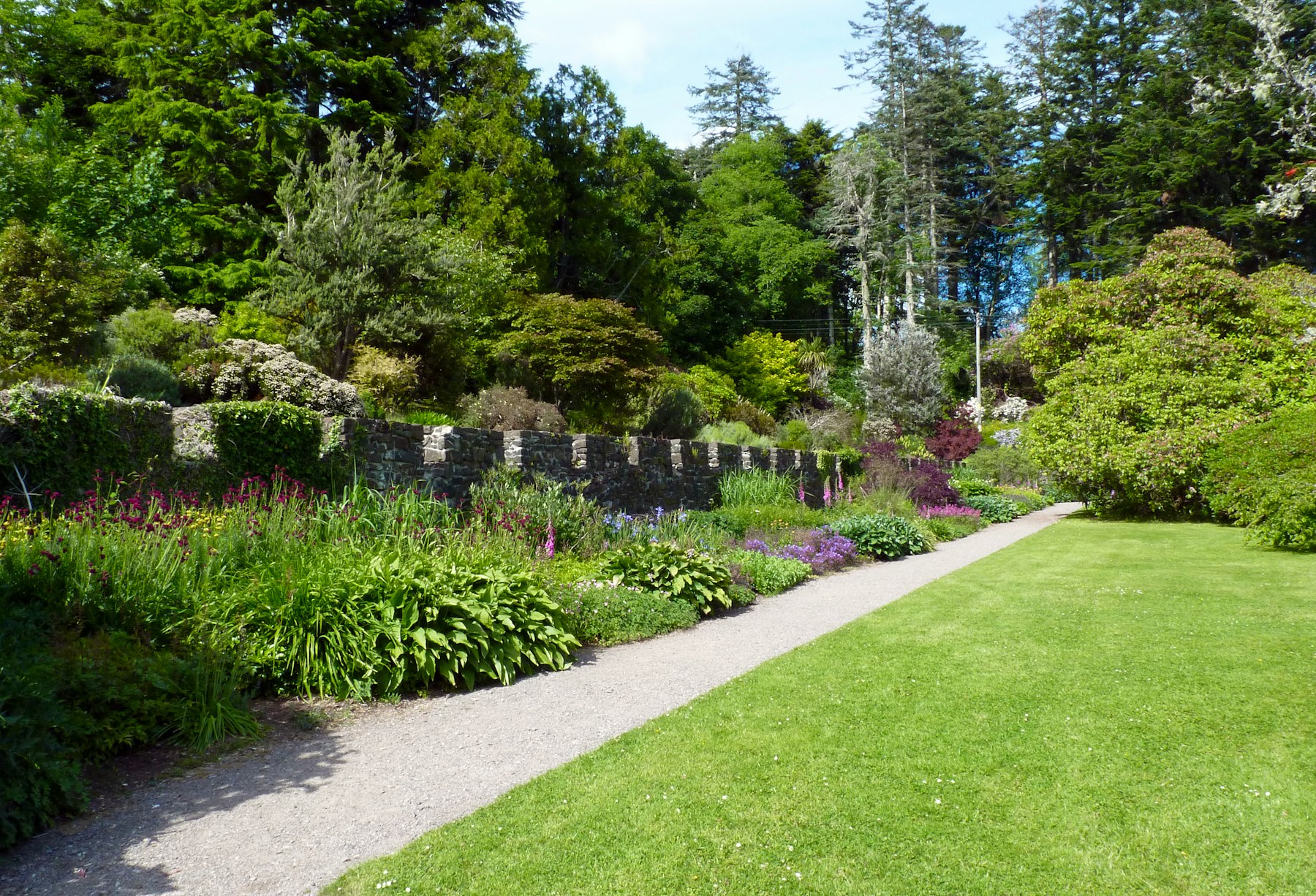 Beispiel für einen gepflegten Gartenweg mit Staudenbeet und Natursteinmauer in Braunschweig